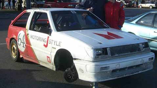 Wheel Falls Off Racing I-Mark, Symbolizes Isuzu's American Experience